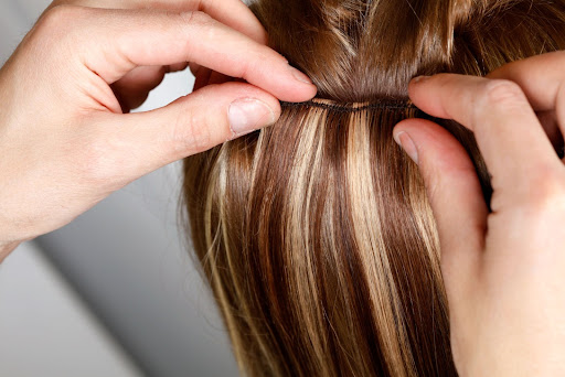 Image of some hair extensions being placed in natural hair Image of some hair extensions being placed in natural hair
